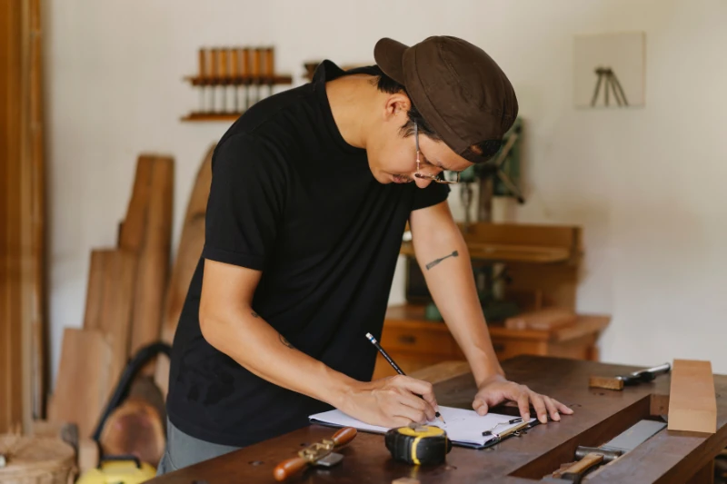 Handwerker skizziert sein Projekt an der Werkbank